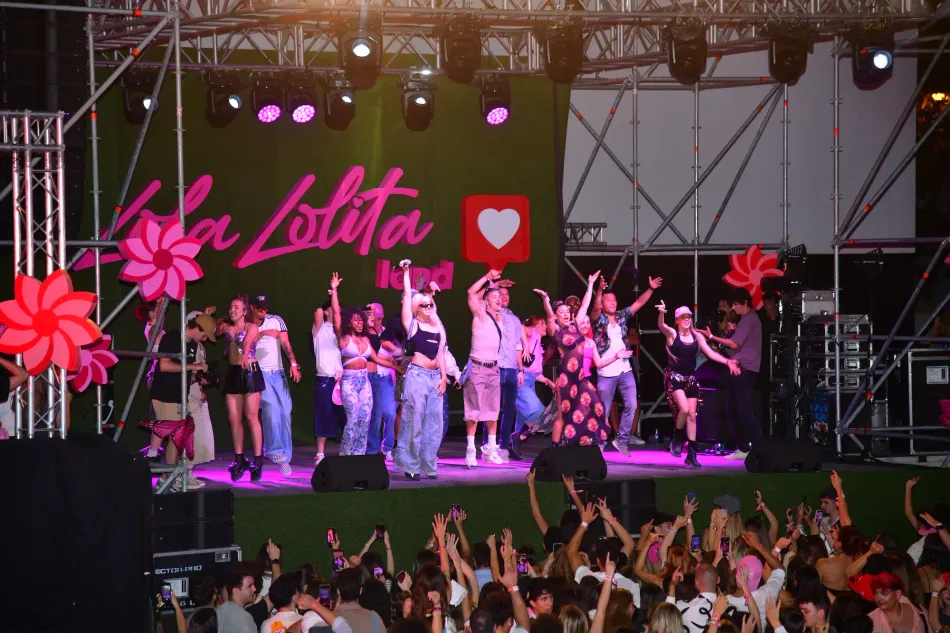 Lola Índigo y otras dos chicas cantando y bailando sobre el escenario.